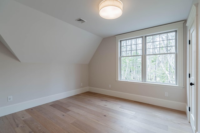 bonus room with a wealth of natural light, light hardwood / wood-style flooring, and vaulted ceiling