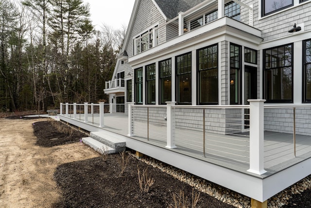 view of property exterior featuring a sunroom and a wooden deck