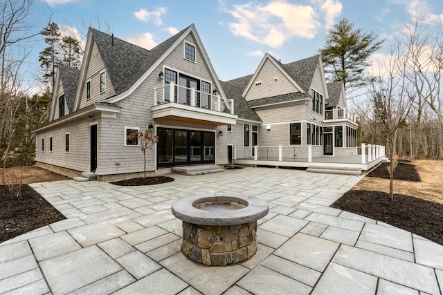 back of property featuring a deck, a patio, and an outdoor fire pit