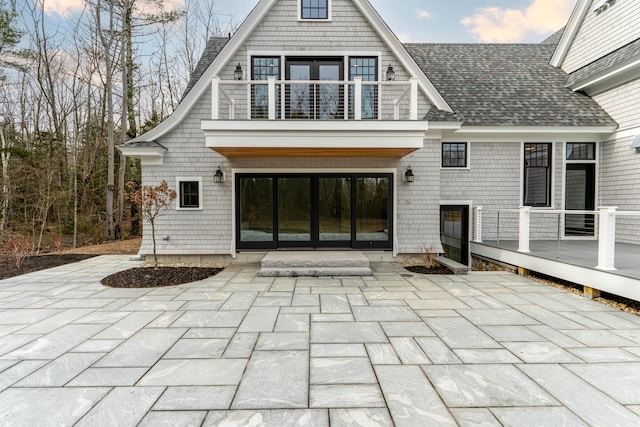 rear view of property with a patio and a balcony