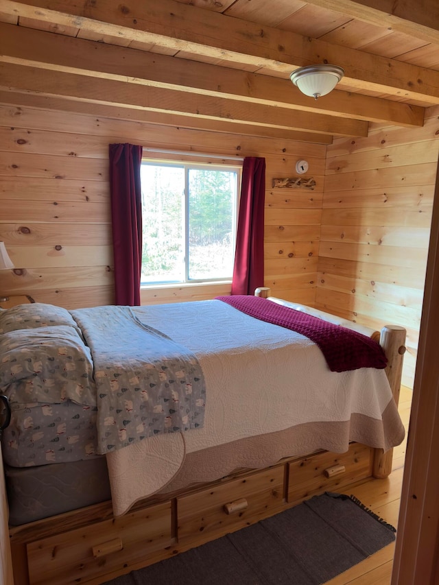 bedroom with wood ceiling, wood-type flooring, wooden walls, and beam ceiling