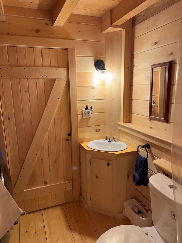 bathroom featuring toilet, wood walls, and wood-type flooring