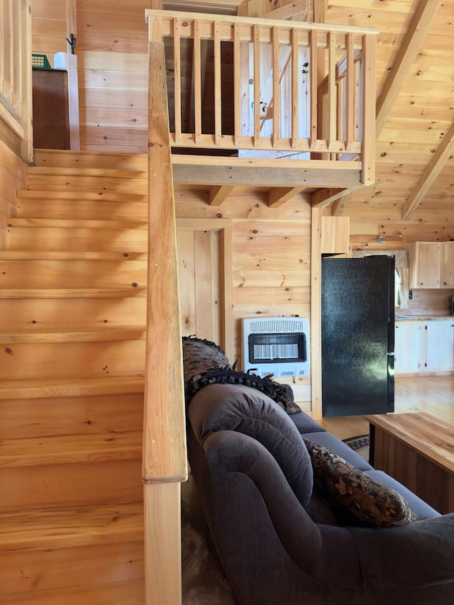 living room featuring heating unit, wooden walls, wood ceiling, and beam ceiling