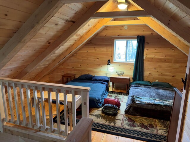 bedroom featuring wooden ceiling, hardwood / wood-style flooring, wooden walls, and vaulted ceiling with beams