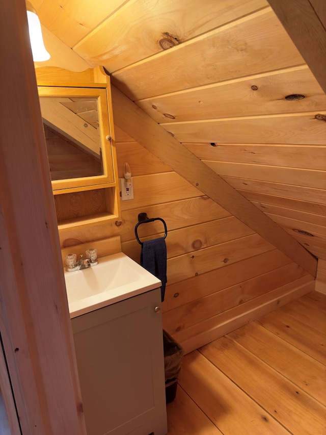 bathroom with vanity, wooden walls, and wood-type flooring