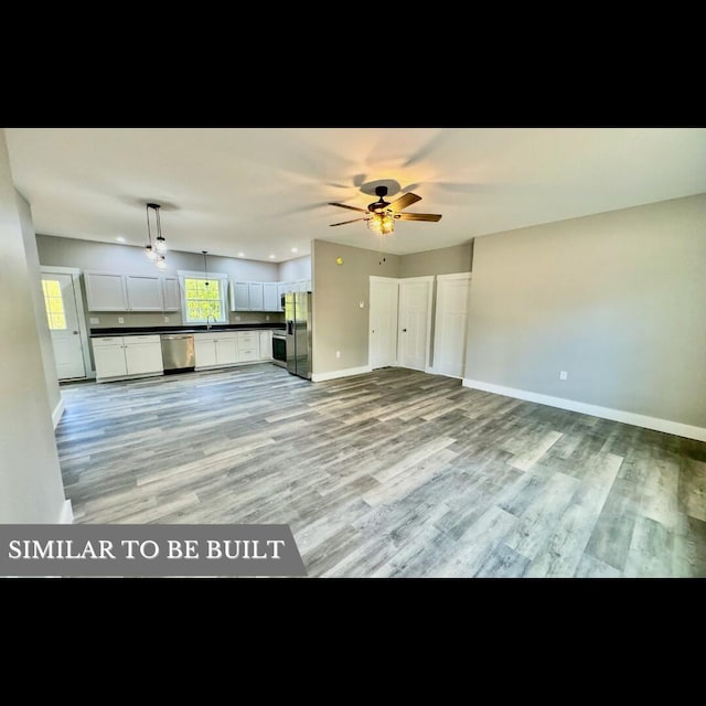 kitchen with ceiling fan, appliances with stainless steel finishes, decorative light fixtures, light hardwood / wood-style floors, and white cabinetry