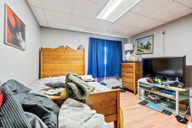 bedroom with wood-type flooring and a paneled ceiling