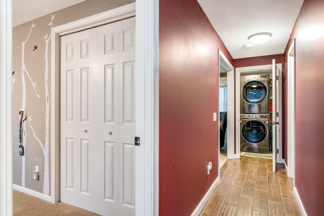 hall featuring stacked washer / dryer and light wood-type flooring