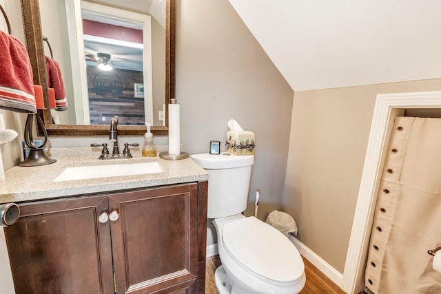 bathroom featuring lofted ceiling, hardwood / wood-style flooring, toilet, and vanity