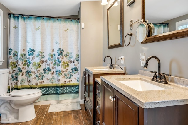 bathroom featuring hardwood / wood-style floors, walk in shower, vanity, and toilet