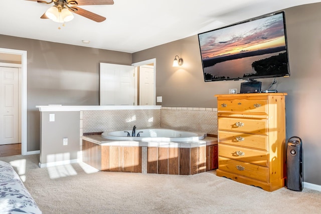 bathroom with tiled bath and ceiling fan