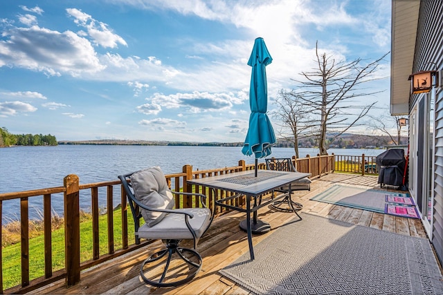 deck with a grill and a water view