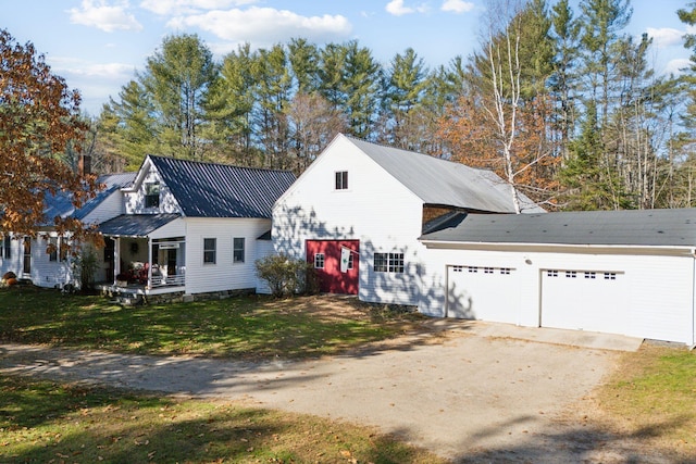 view of front facade with covered porch, a garage, and a front lawn