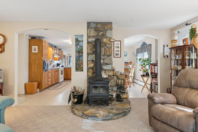 living room featuring a baseboard radiator and a wood stove