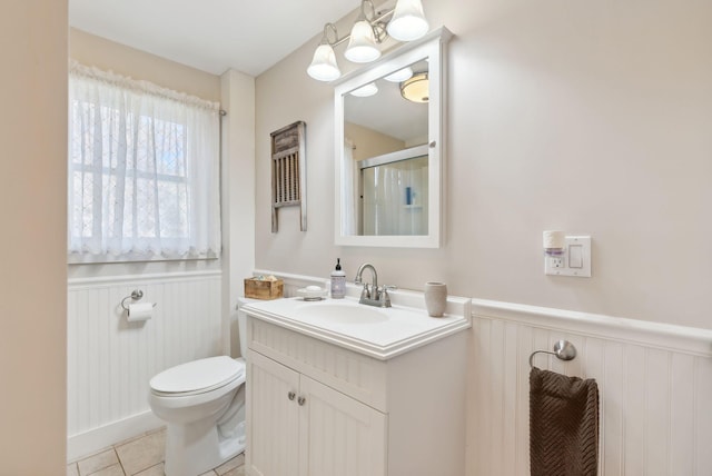 bathroom featuring tile patterned floors, vanity, toilet, and walk in shower