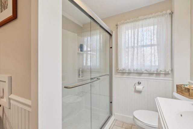 bathroom featuring tile patterned flooring, vanity, toilet, and walk in shower