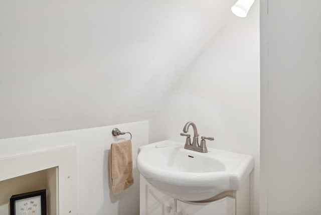 bathroom featuring vanity and lofted ceiling