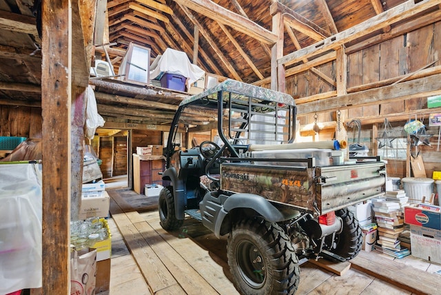 misc room featuring wooden walls, hardwood / wood-style floors, and vaulted ceiling