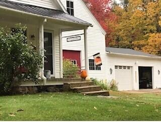 doorway to property with a lawn and a garage