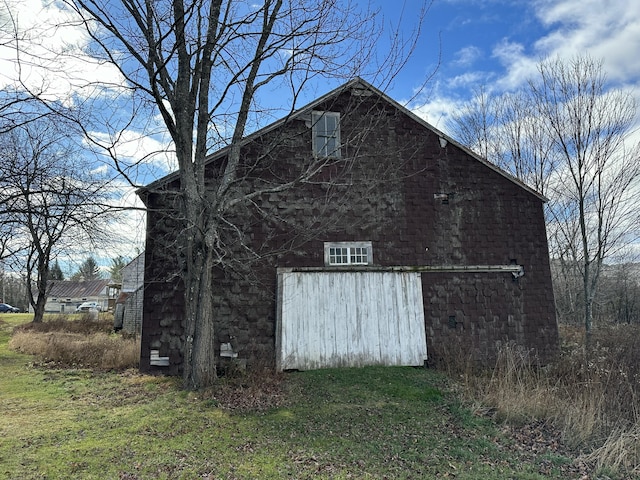 view of side of home with a lawn and an outdoor structure