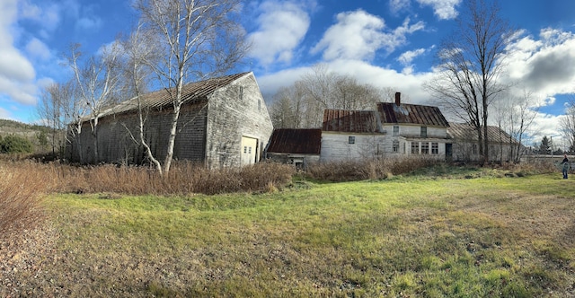 view of side of home with a garage, a yard, an outbuilding, and a barn