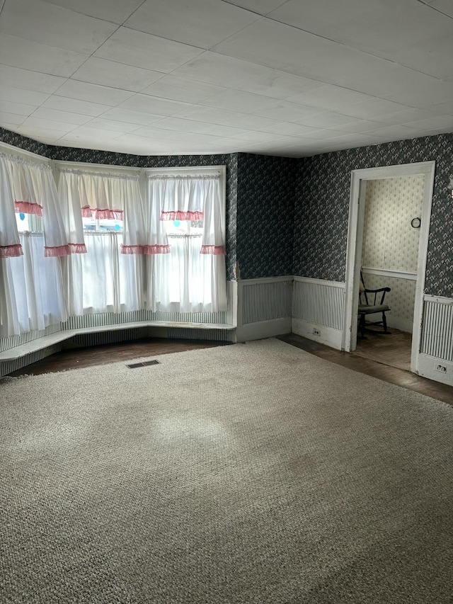 empty room featuring visible vents and wallpapered walls