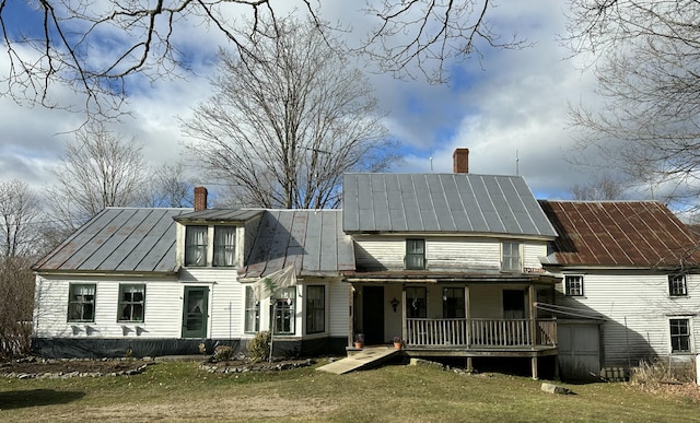 rear view of property featuring a standing seam roof, metal roof, and a chimney