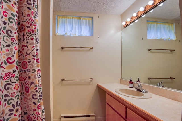 bathroom with a baseboard radiator, vanity, and a textured ceiling