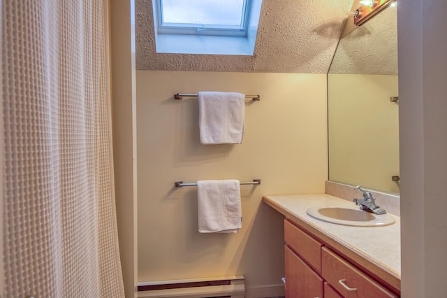 bathroom featuring vanity, a skylight, and a textured ceiling