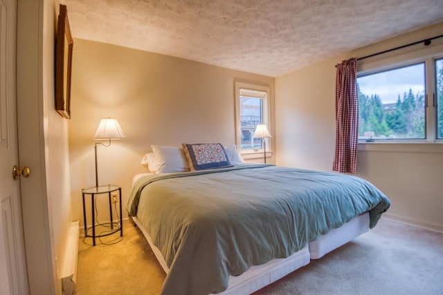 carpeted bedroom featuring multiple windows and a textured ceiling