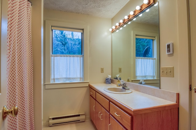 bathroom with baseboard heating, vanity, and a textured ceiling