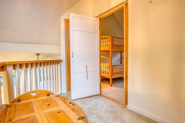 bedroom featuring carpet, a textured ceiling, and vaulted ceiling