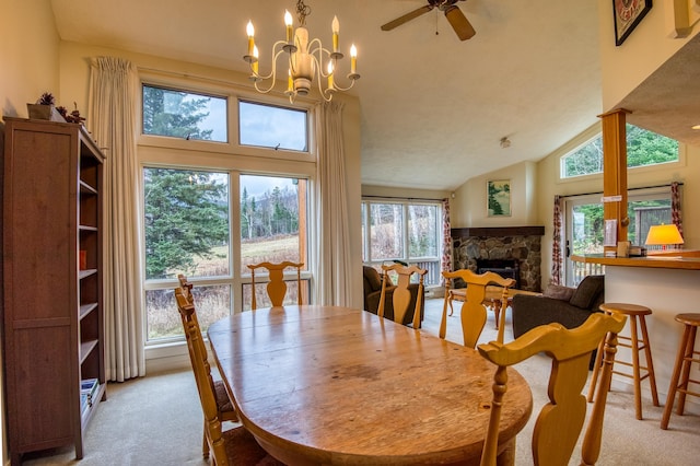 carpeted dining area featuring a fireplace, ceiling fan with notable chandelier, and high vaulted ceiling