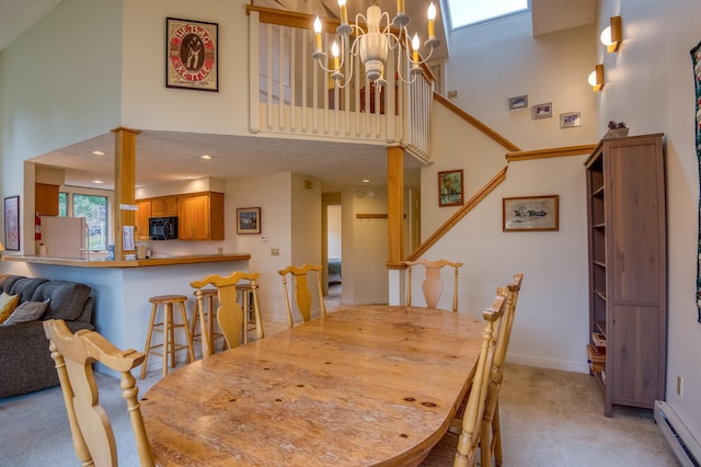 carpeted dining space with a high ceiling, a baseboard radiator, an inviting chandelier, and a textured ceiling