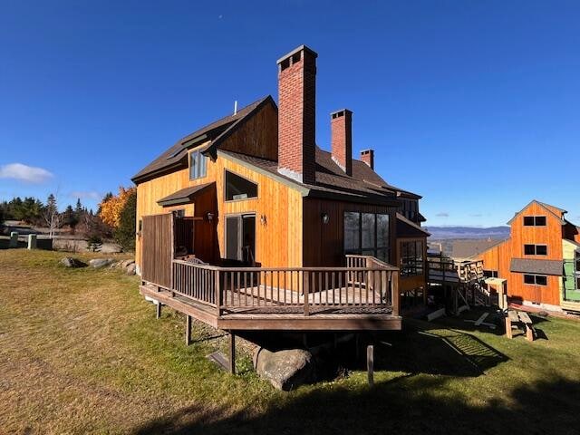 back of house with a lawn and a deck