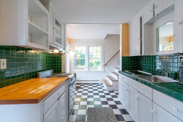 kitchen featuring white cabinets, stainless steel range oven, sink, baseboard heating, and backsplash