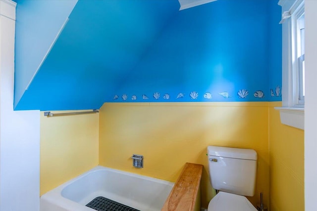 bathroom featuring toilet, lofted ceiling, and a bathtub