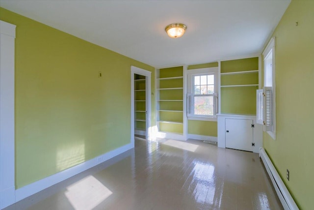 unfurnished room with baseboard heating and light wood-type flooring