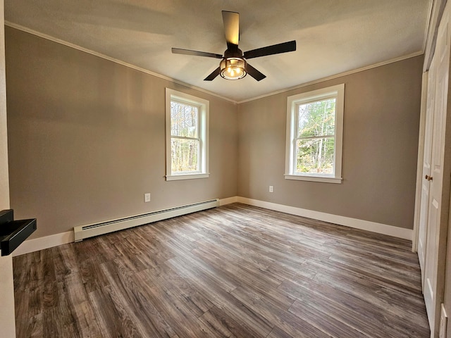 spare room with a healthy amount of sunlight, a baseboard radiator, and hardwood / wood-style flooring