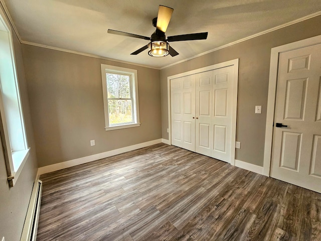 unfurnished bedroom with ornamental molding, ceiling fan, wood-type flooring, a baseboard radiator, and a closet