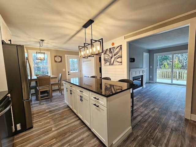 kitchen with white cabinets, decorative light fixtures, and a healthy amount of sunlight