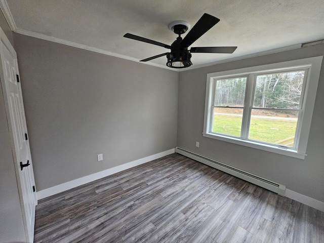 spare room featuring crown molding, ceiling fan, a baseboard radiator, and hardwood / wood-style flooring