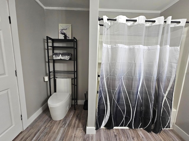 bathroom with shower / bath combo with shower curtain, wood-type flooring, toilet, and ornamental molding