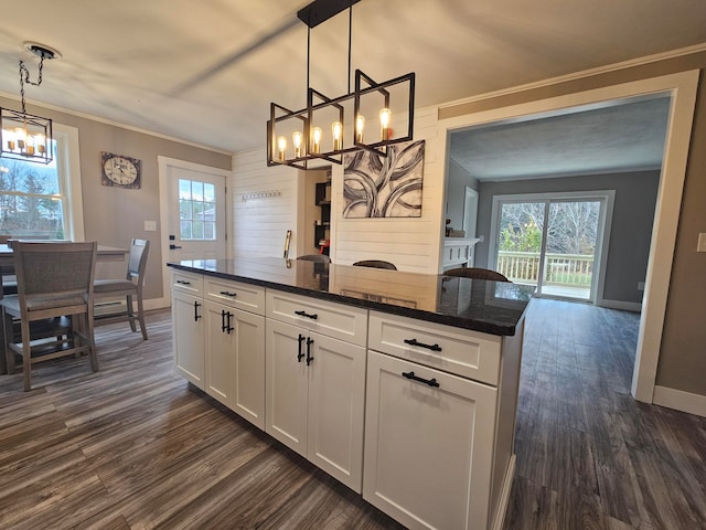 kitchen featuring decorative light fixtures, white cabinetry, dark hardwood / wood-style floors, and dark stone countertops