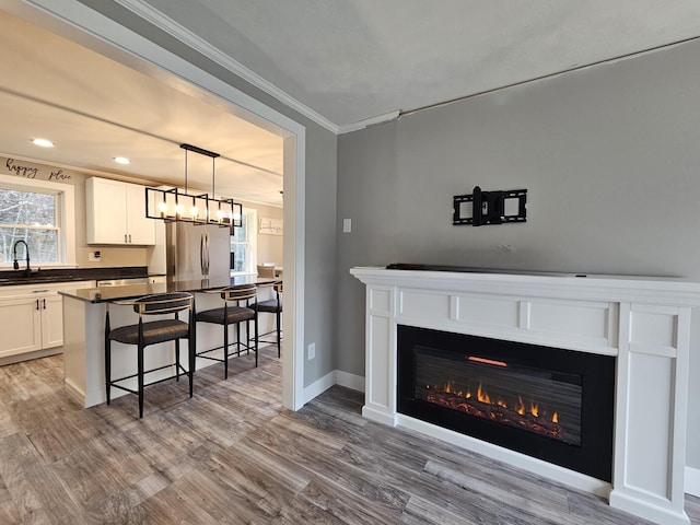 interior space featuring crown molding, light hardwood / wood-style flooring, and sink