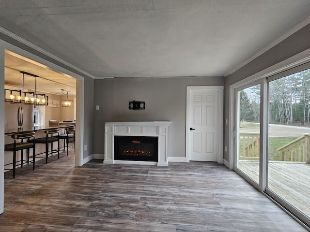 living room with a chandelier, crown molding, and wood-type flooring