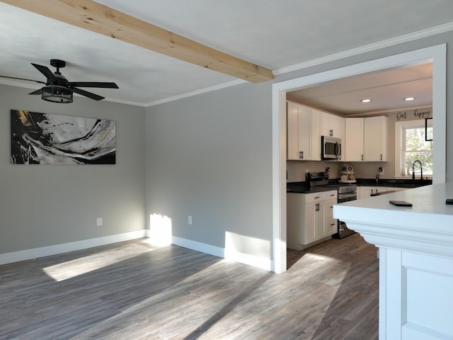 kitchen featuring white cabinetry, ornamental molding, dark hardwood / wood-style floors, and appliances with stainless steel finishes