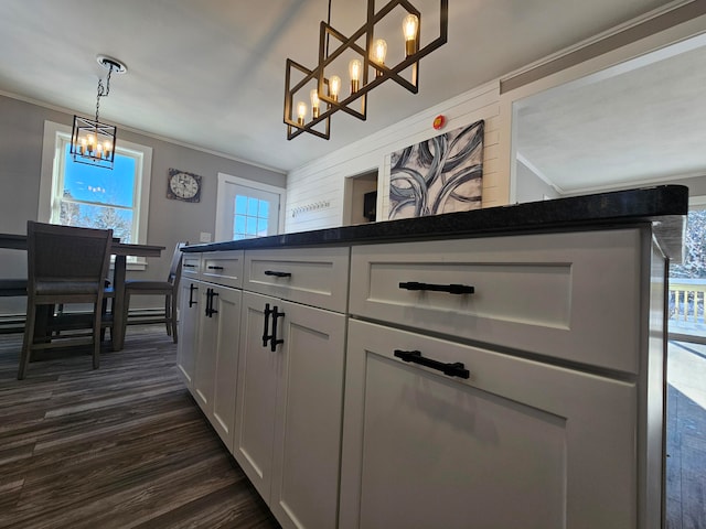 kitchen featuring an inviting chandelier, white cabinetry, hanging light fixtures, and dark hardwood / wood-style floors