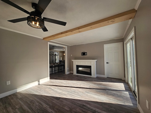 unfurnished living room with beam ceiling, dark wood-type flooring, a textured ceiling, ceiling fan with notable chandelier, and ornamental molding