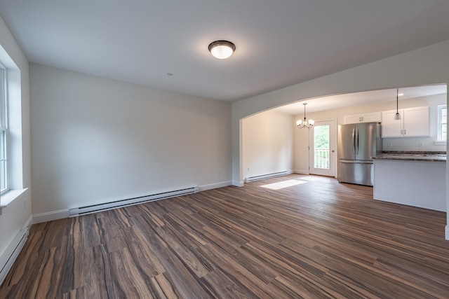 unfurnished living room featuring dark hardwood / wood-style floors and a baseboard heating unit